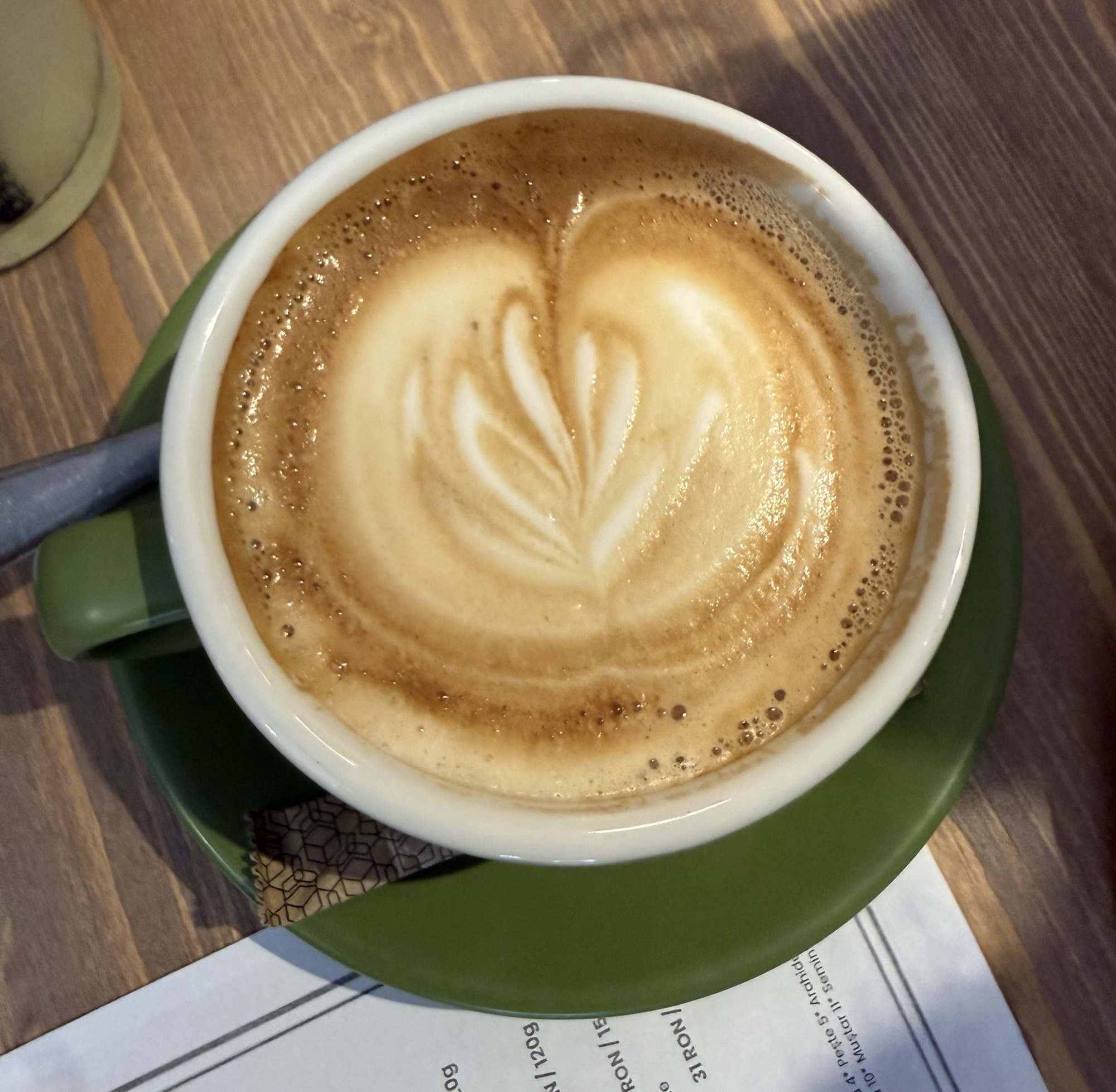 Cafea cu lapte cu latte art, în ceașcă verde